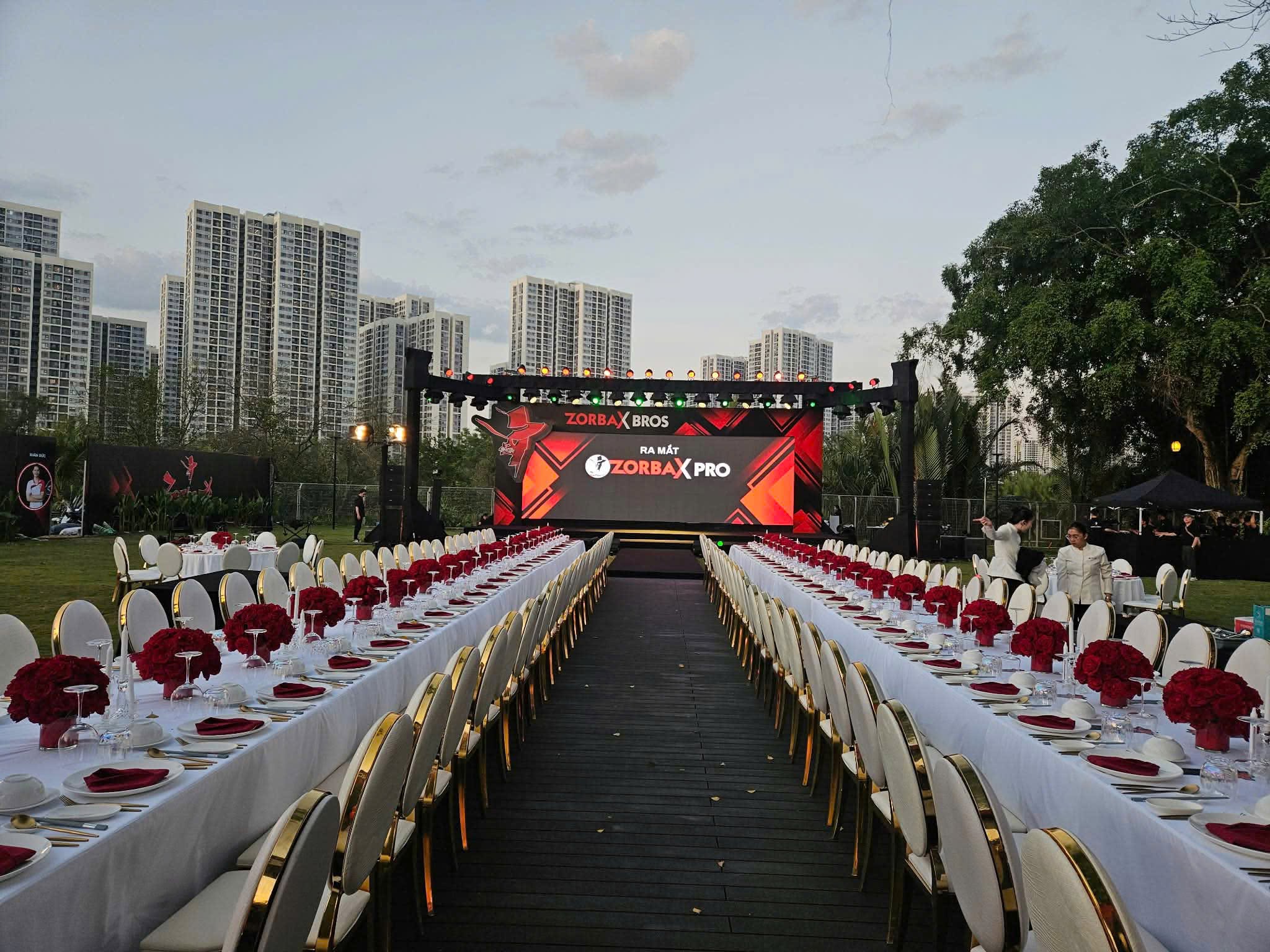 An outdoor corporate dinner setup with a central LED stage produced by Medusa AVL.