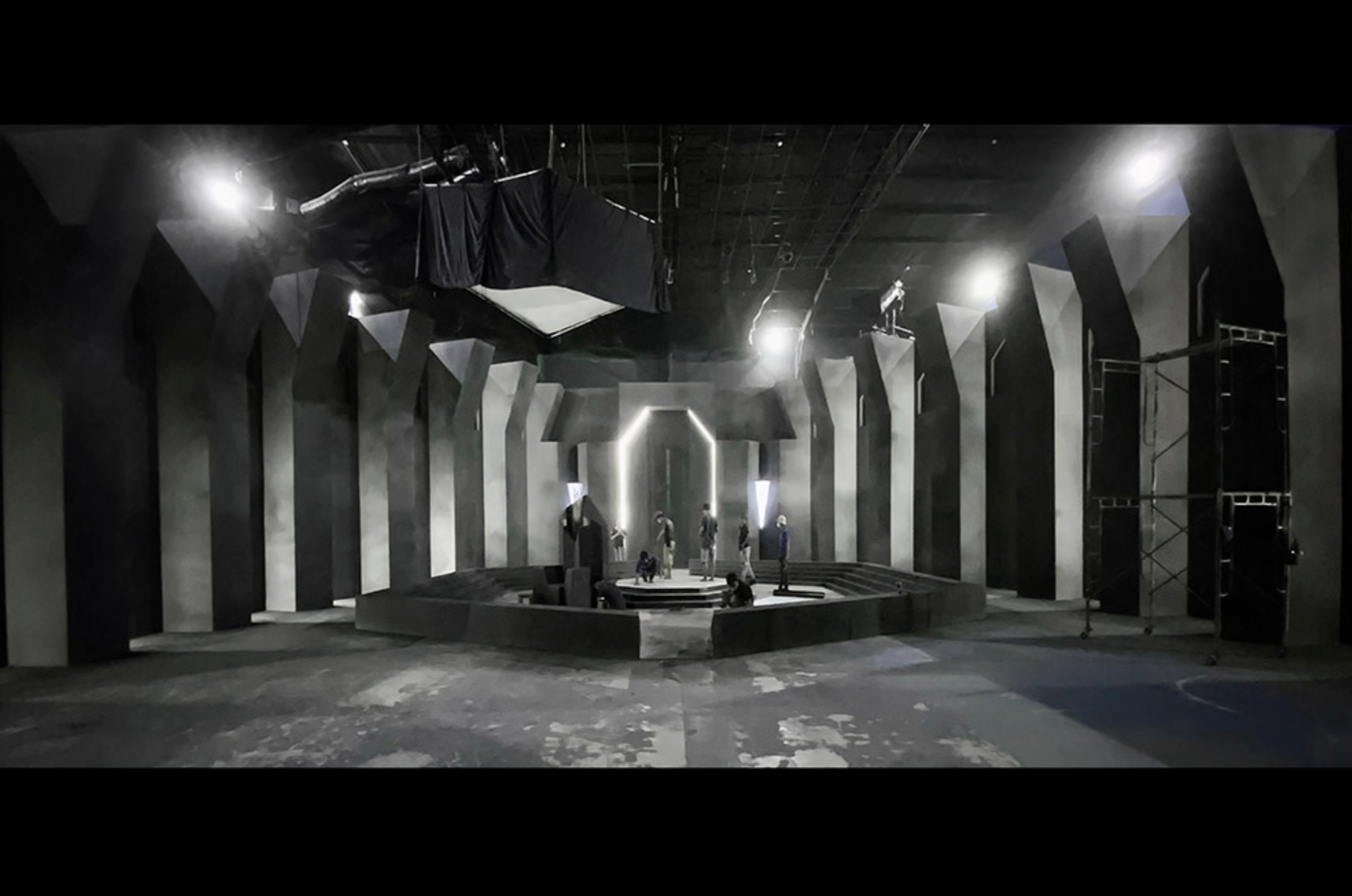 A Travipome production-design installation with a monochrome stage and sculptural columns.